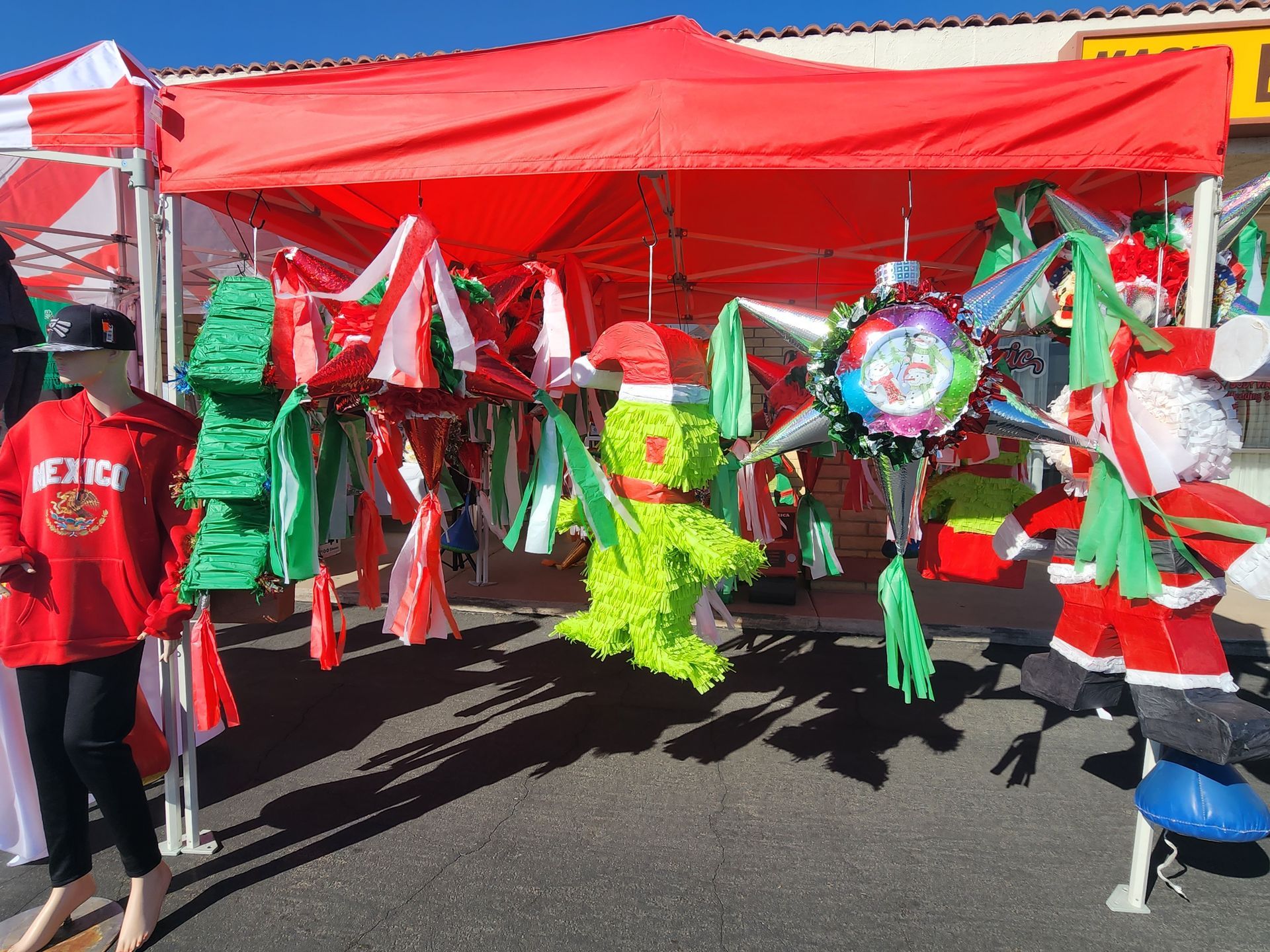 a red tent with a bunch of christmas pinatas hanging from it