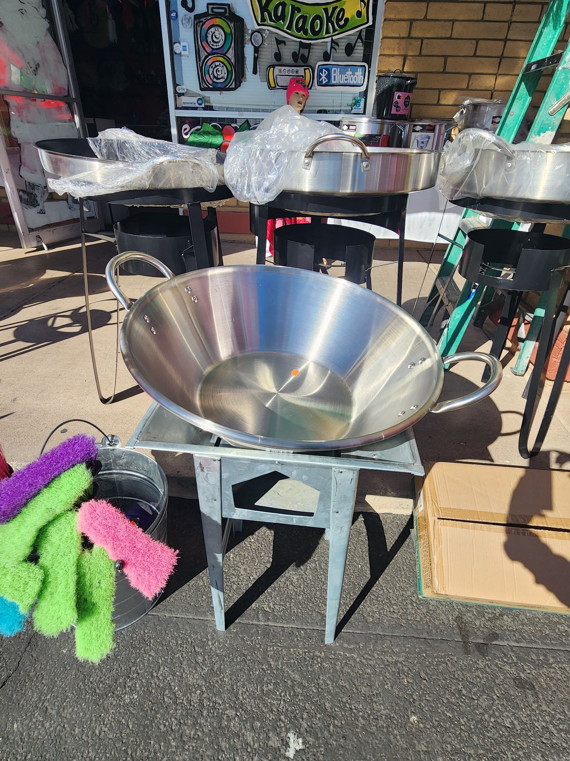 a large stainless steel pan is sitting on top of a small table .