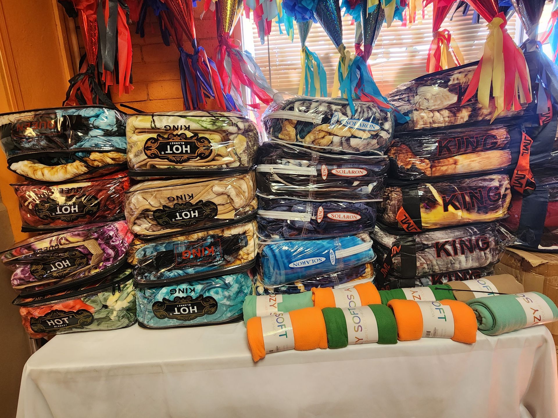 a table with a bunch of blankets stacked on top of each other .