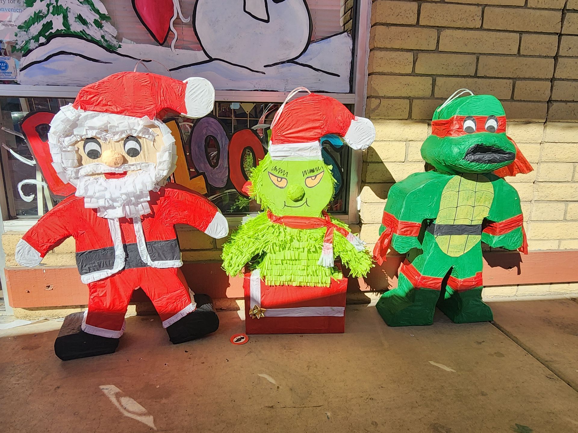 a santa claus , a grinch and a teenage mutant ninja turtle pinata