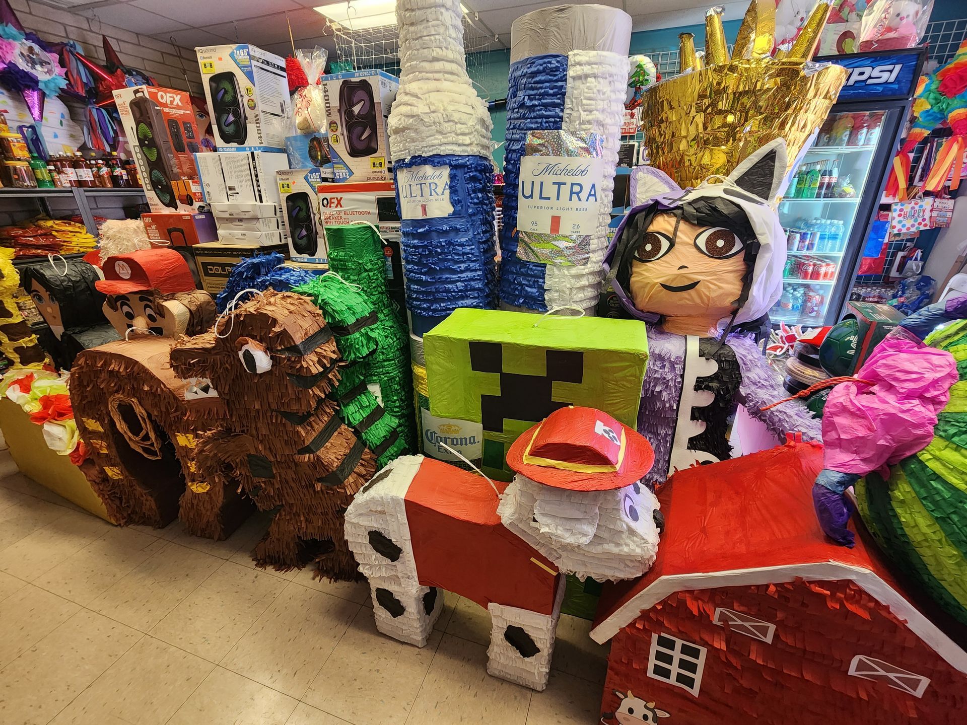 a bunch of pinatas are sitting on the floor in a store .