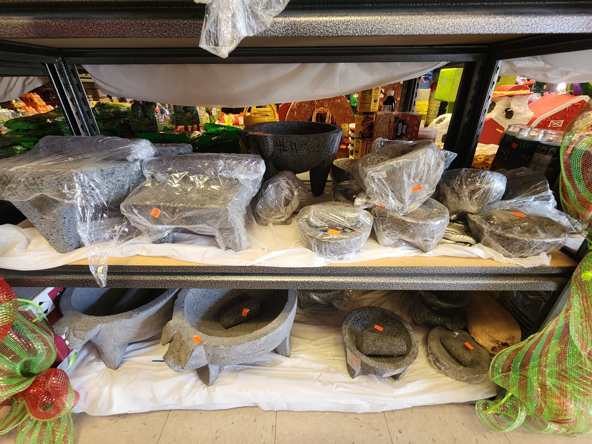a shelf filled with a variety of ceramic pots and bowls .