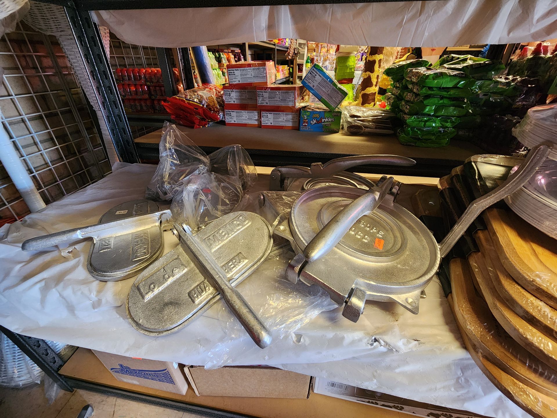 a bunch of cooking utensils are sitting on a table in a store .