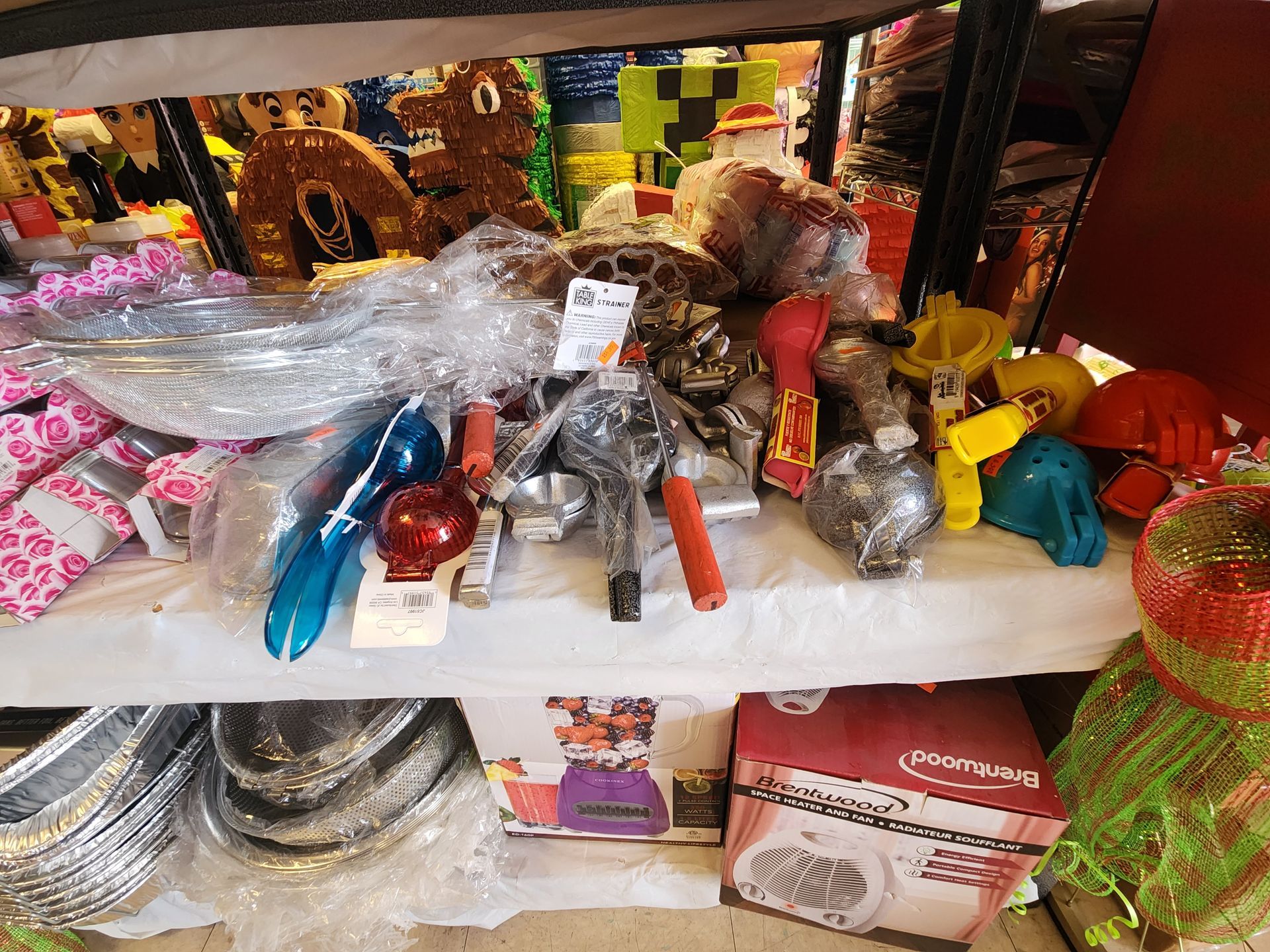a shelf filled with a variety of items including balloons and plates .