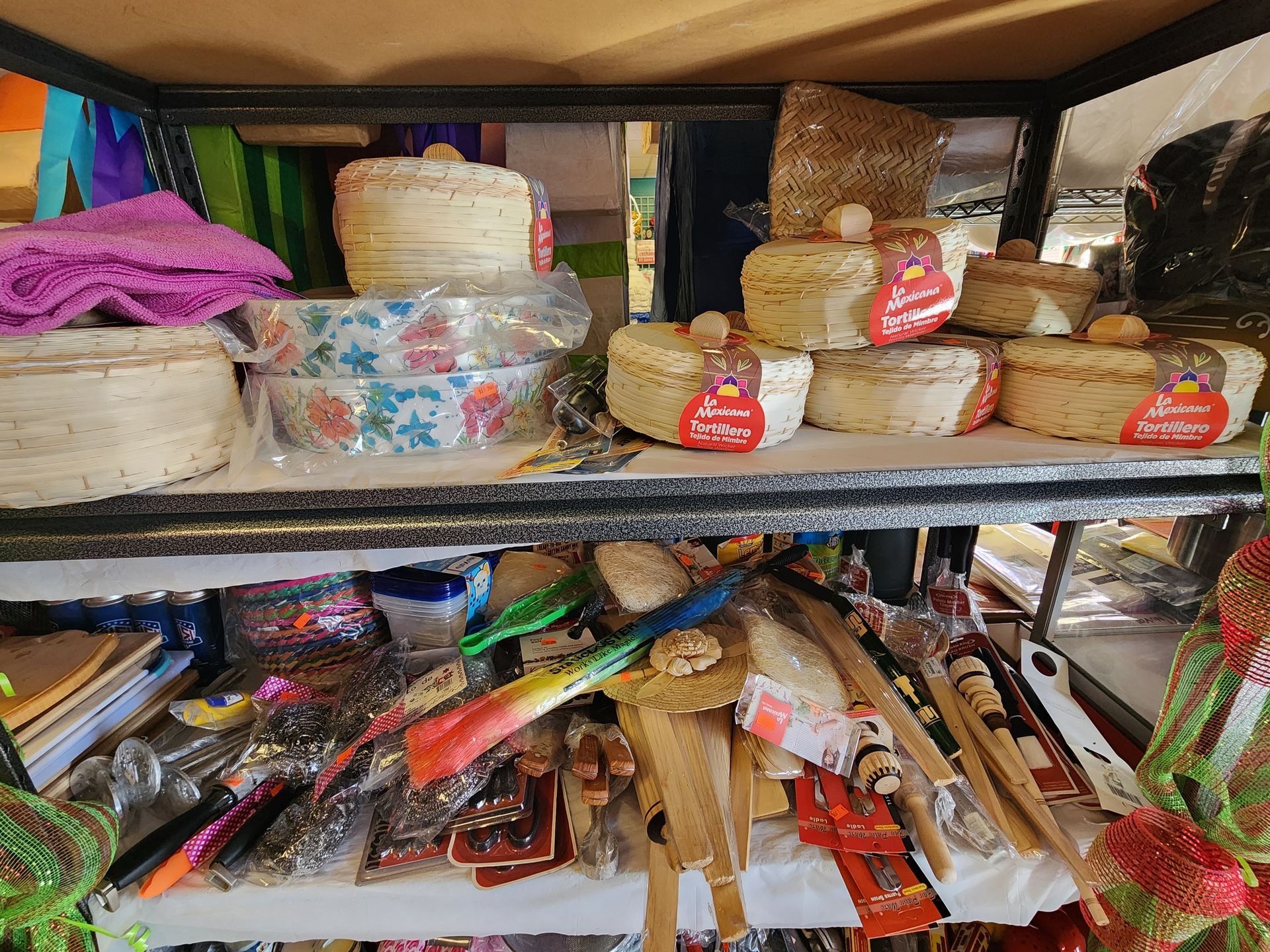 a shelf filled with a variety of items including baskets and brushes .