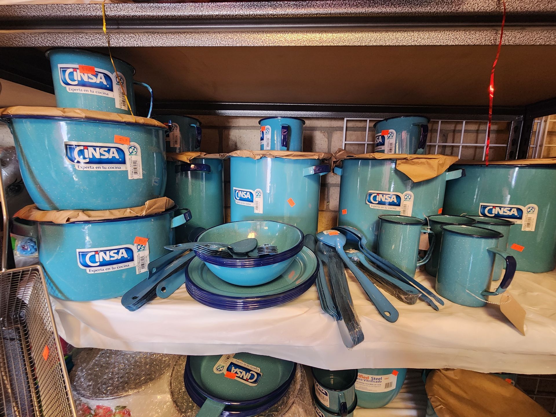 a shelf filled with lots of blue pots and pans