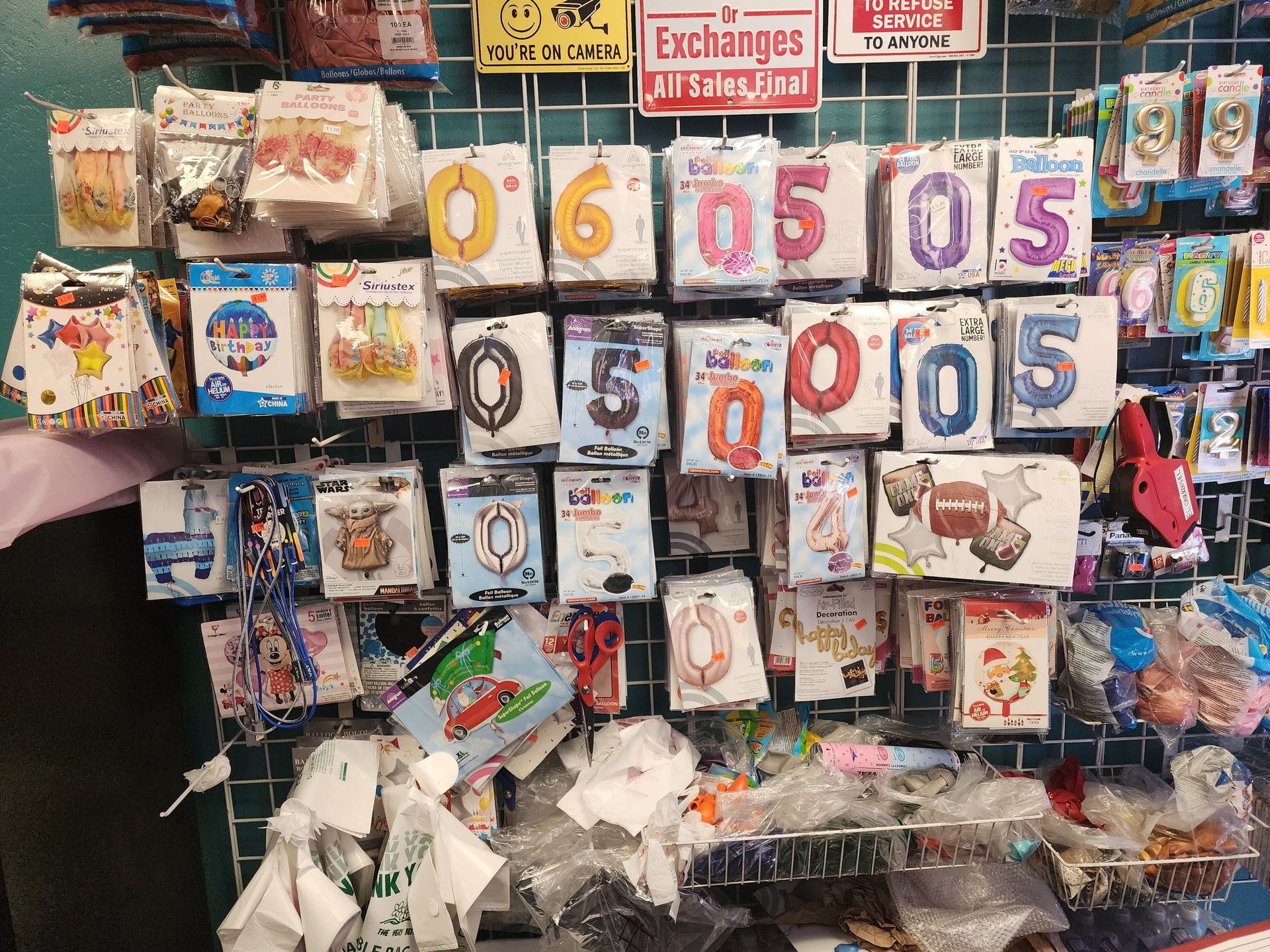 a bunch of balloons are hanging on a wall in a store .