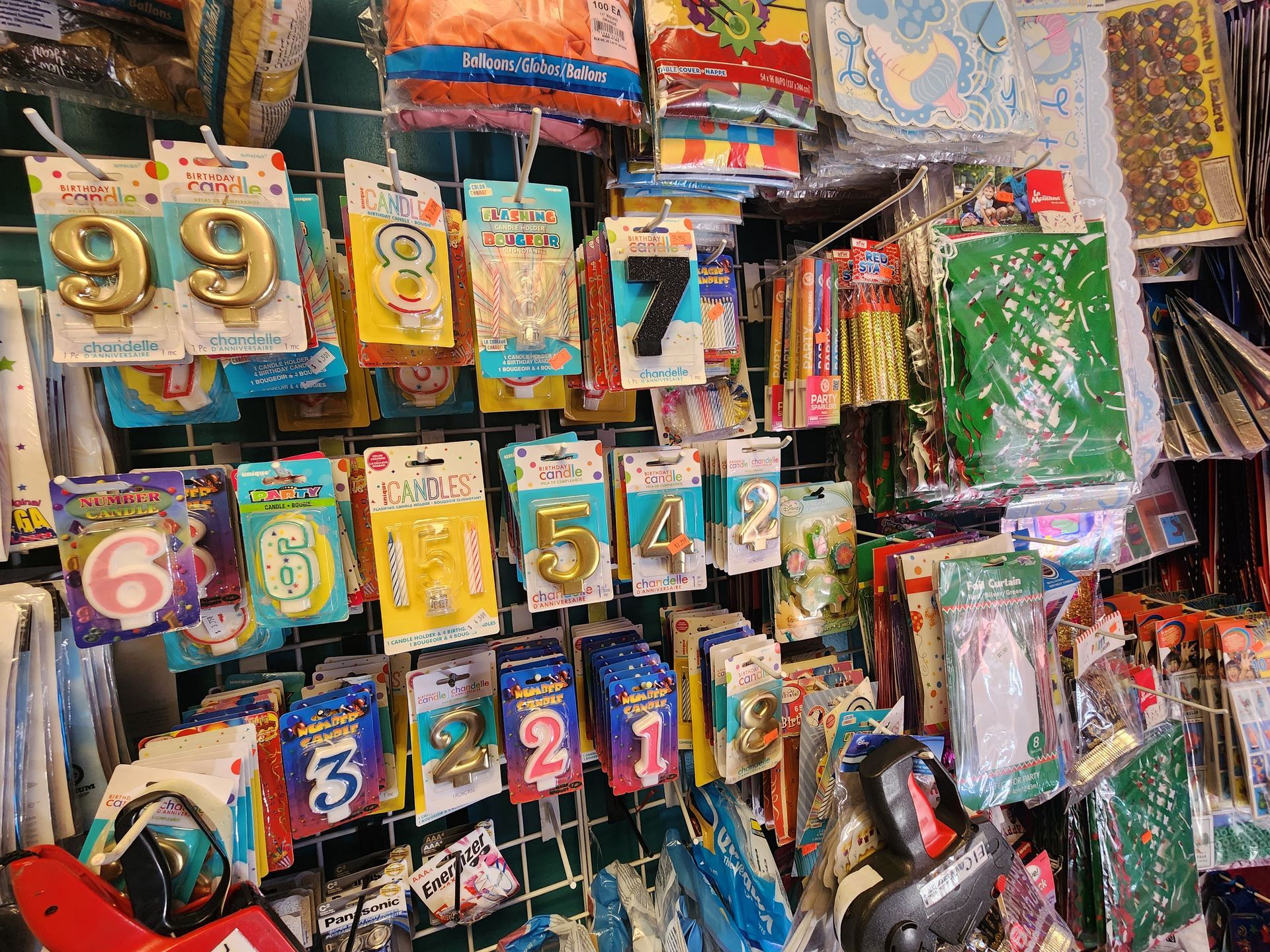 a bunch of number balloons are hanging on a wall in a store .