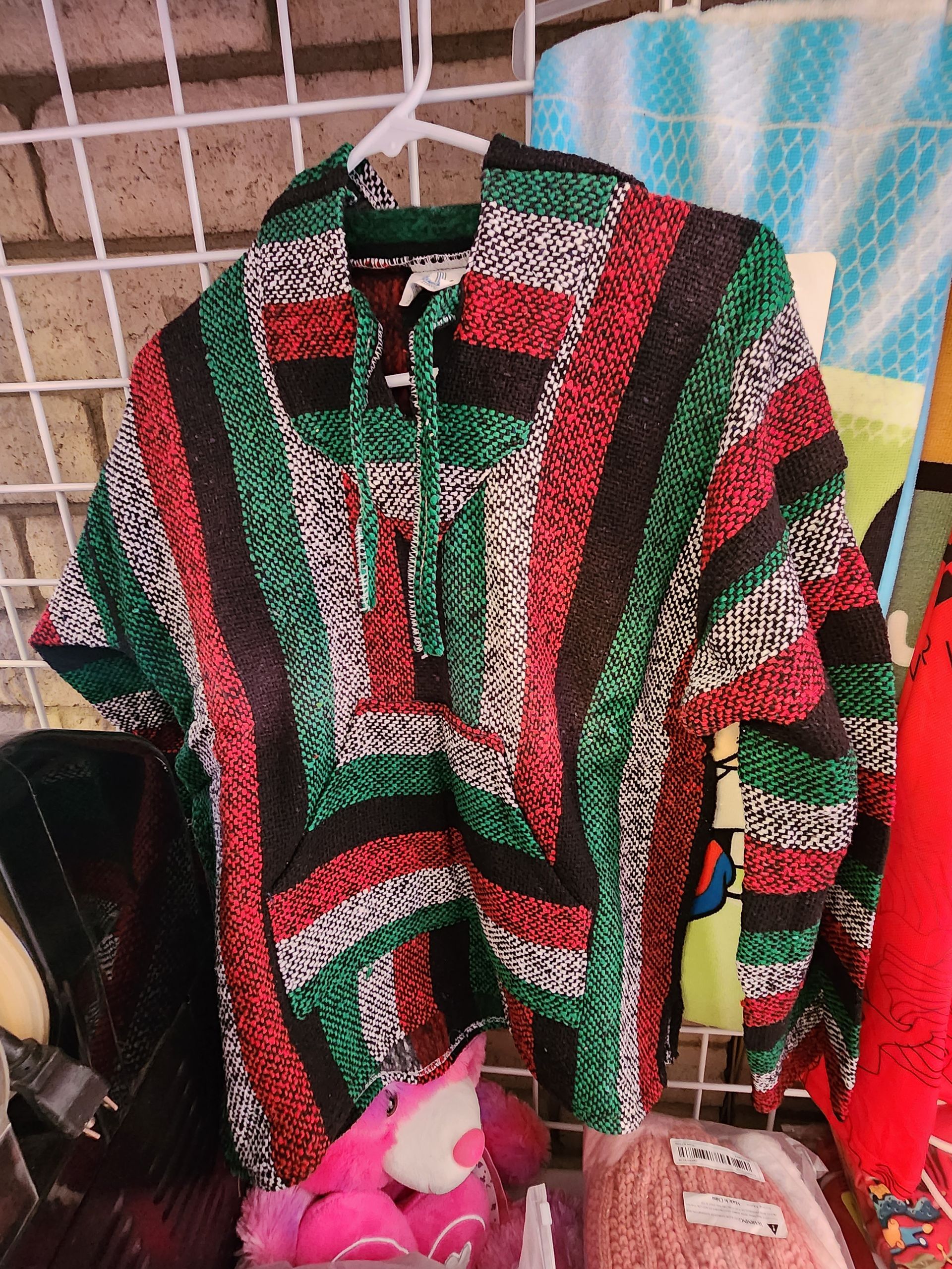 a red , green and white sweater is hanging on a hanger .