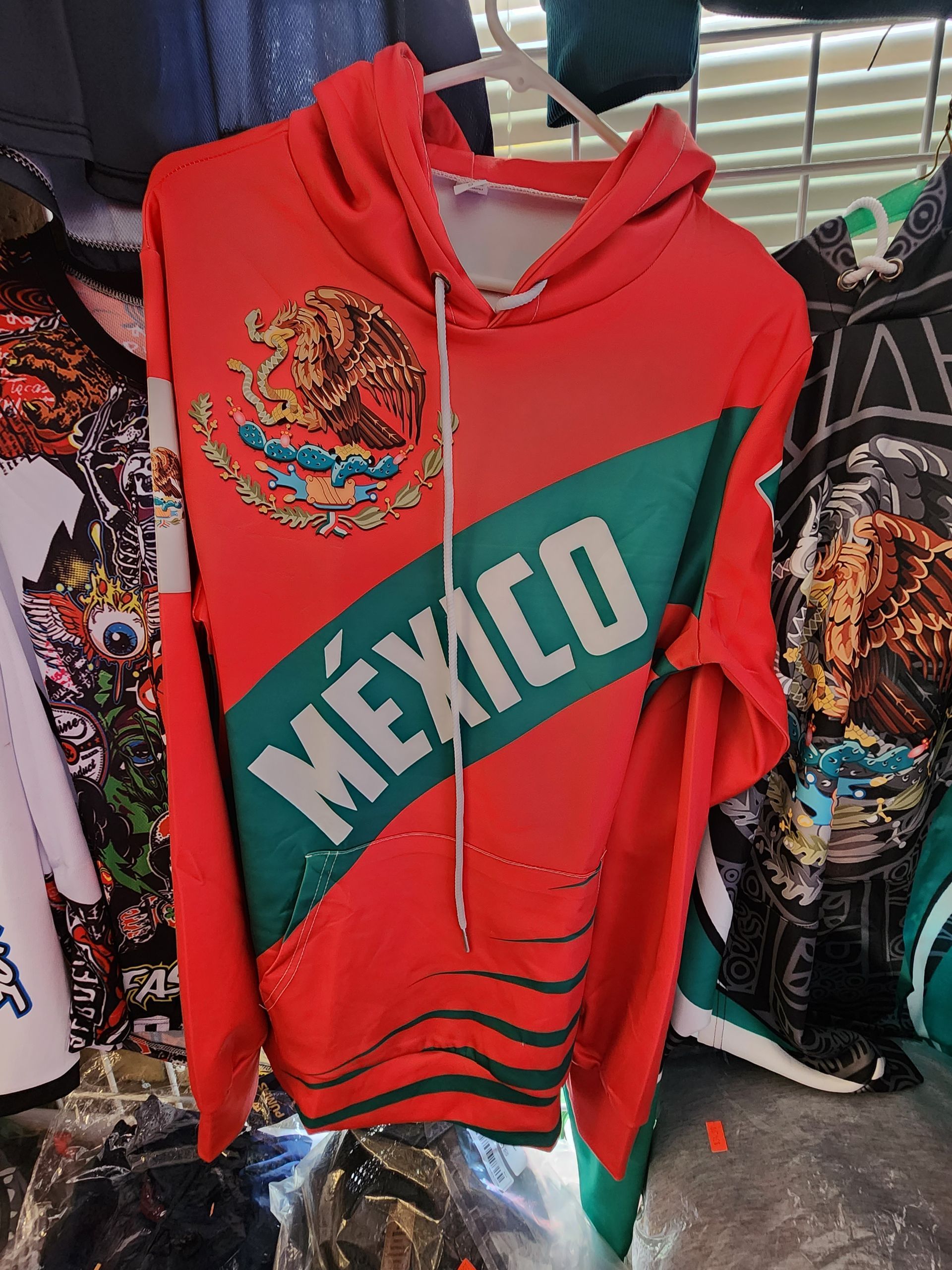 a red mexico hoodie is hanging on a rack