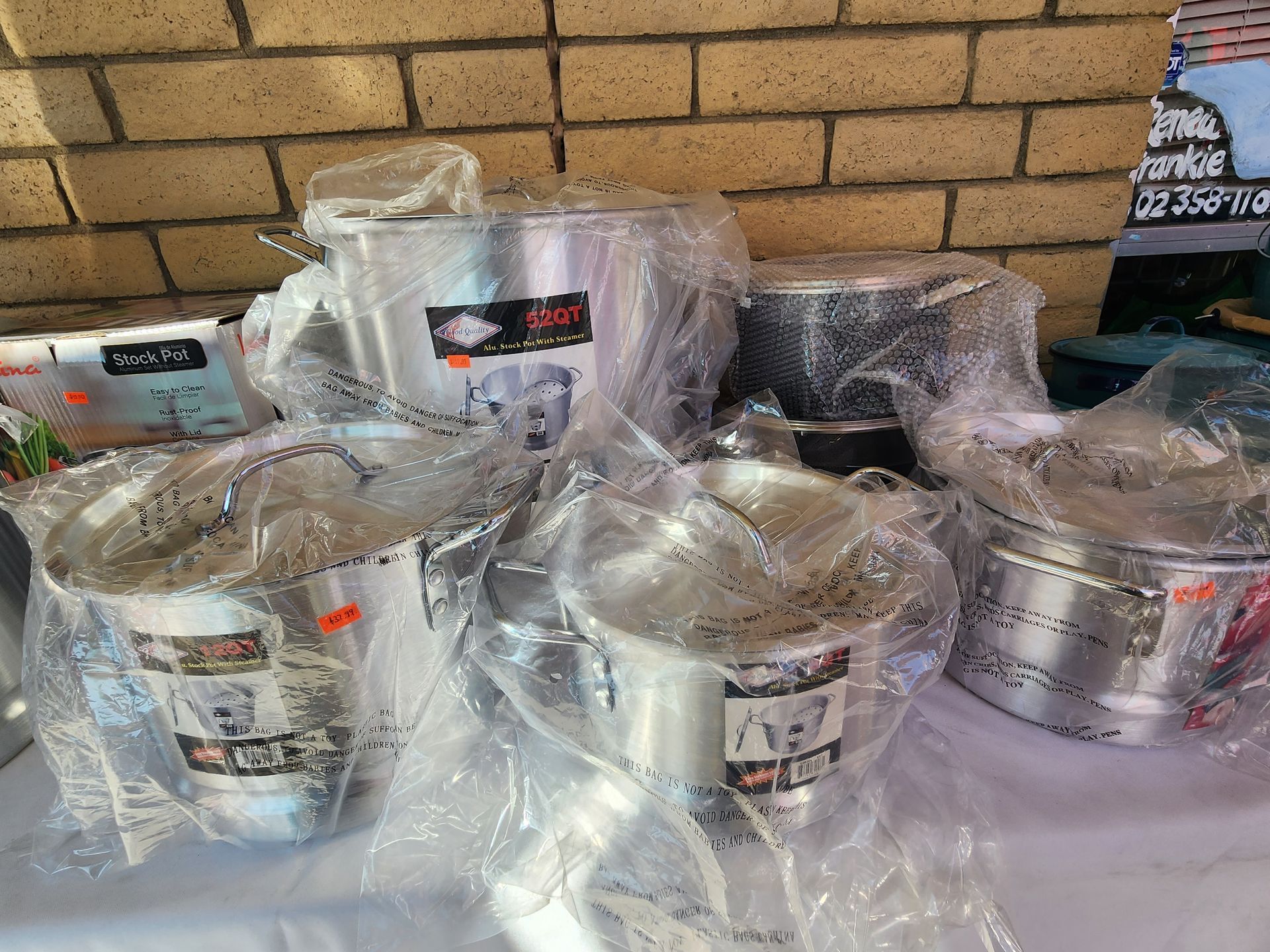 a table topped with a bunch of pots and pans wrapped in plastic .