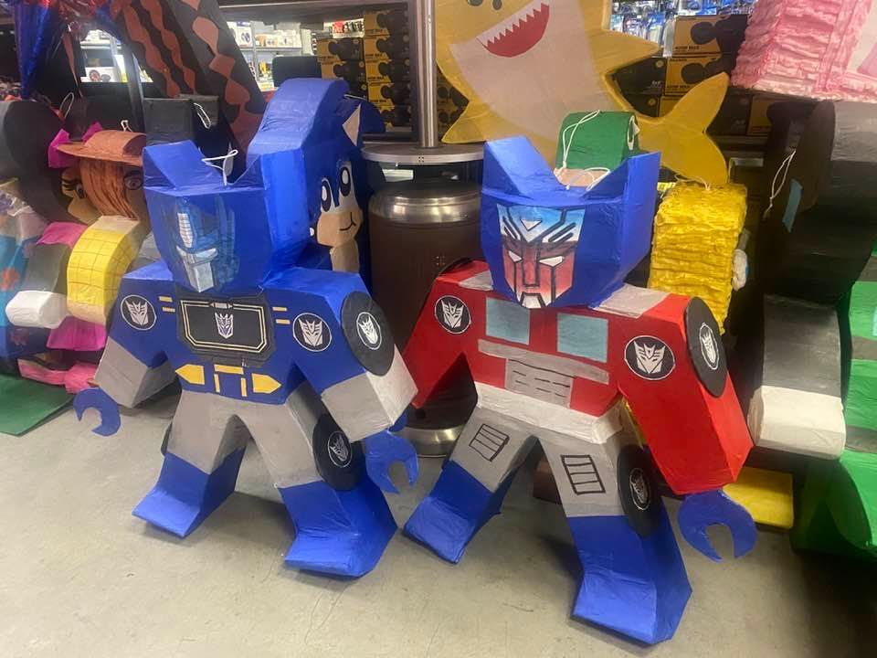 two transformers made out of cardboard are standing next to each other on a table .