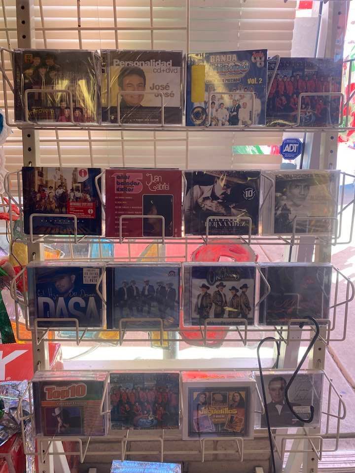 a bunch of cds are sitting on a rack in a store .