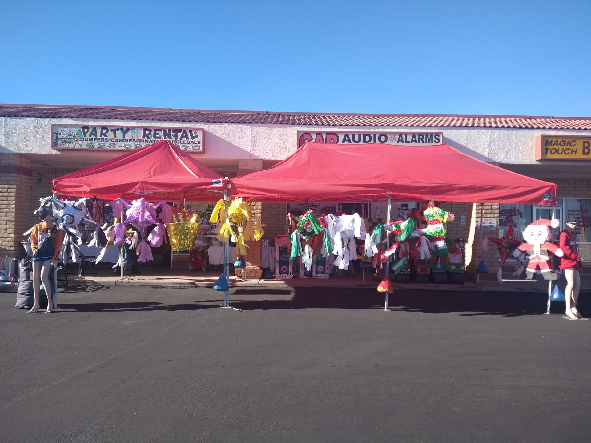 a store front with red tents and balloons in front of it