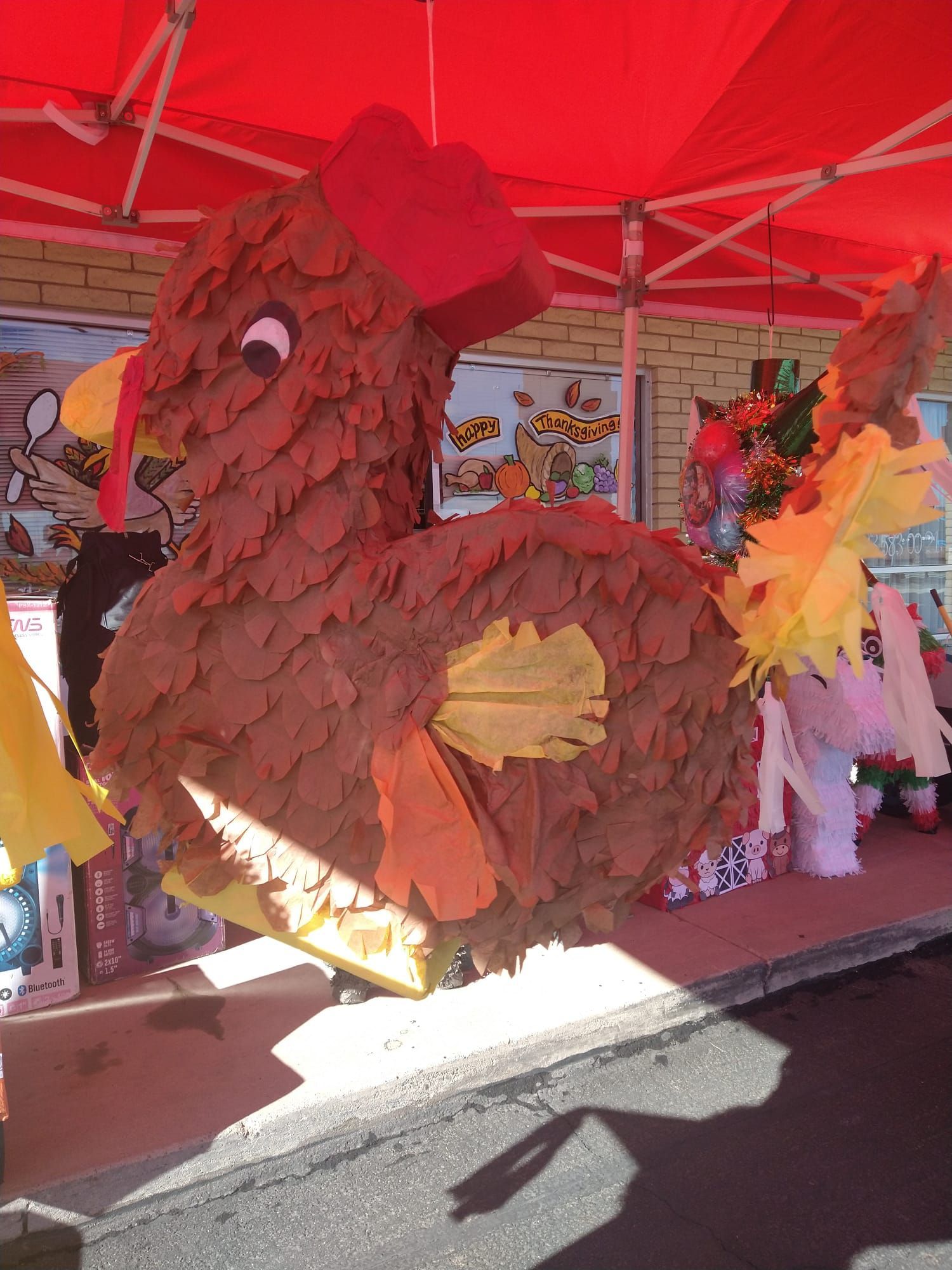 a chicken piñata is sitting under a red tent