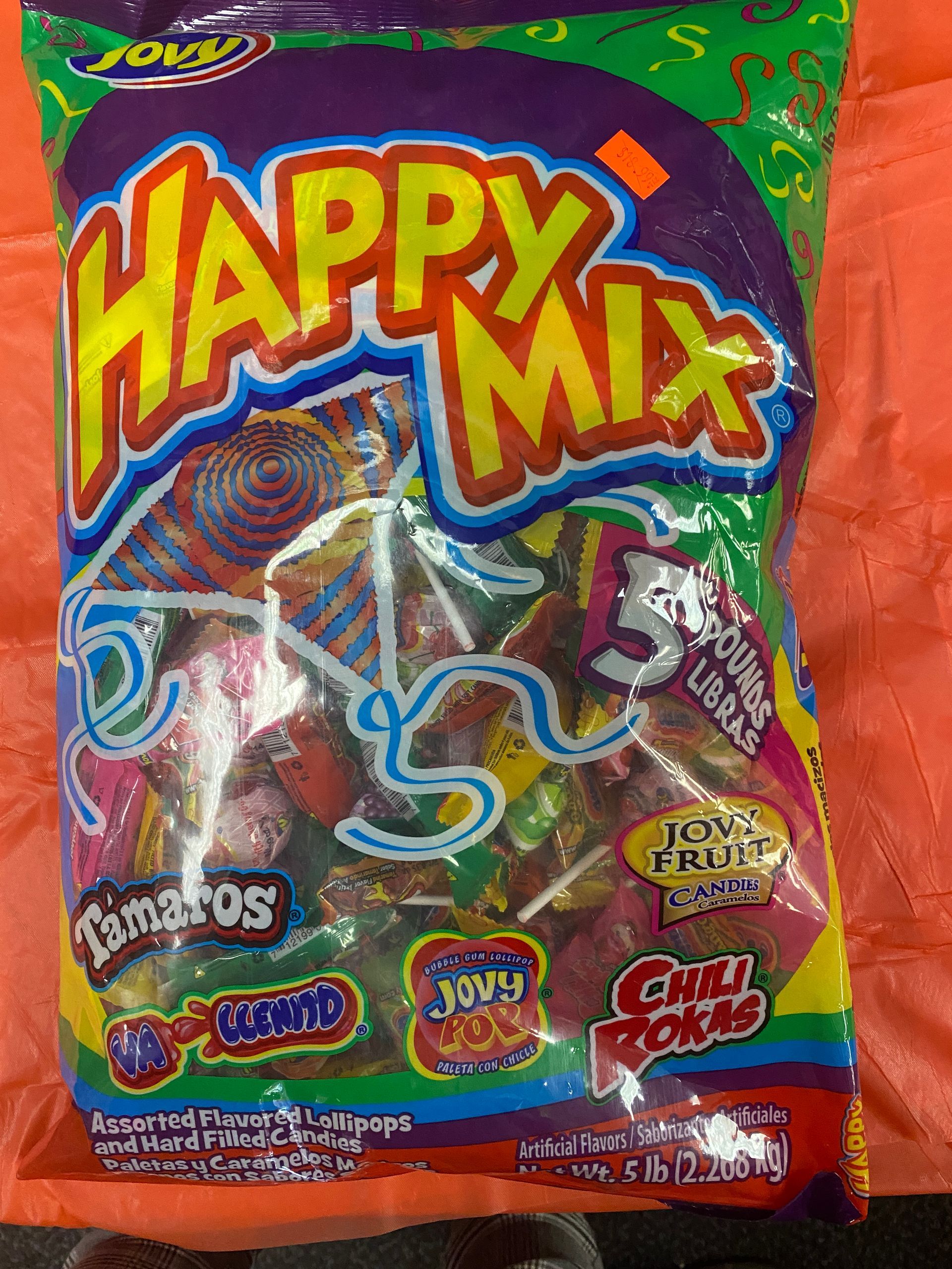 a bag of happy mix lollipops is sitting on a table .