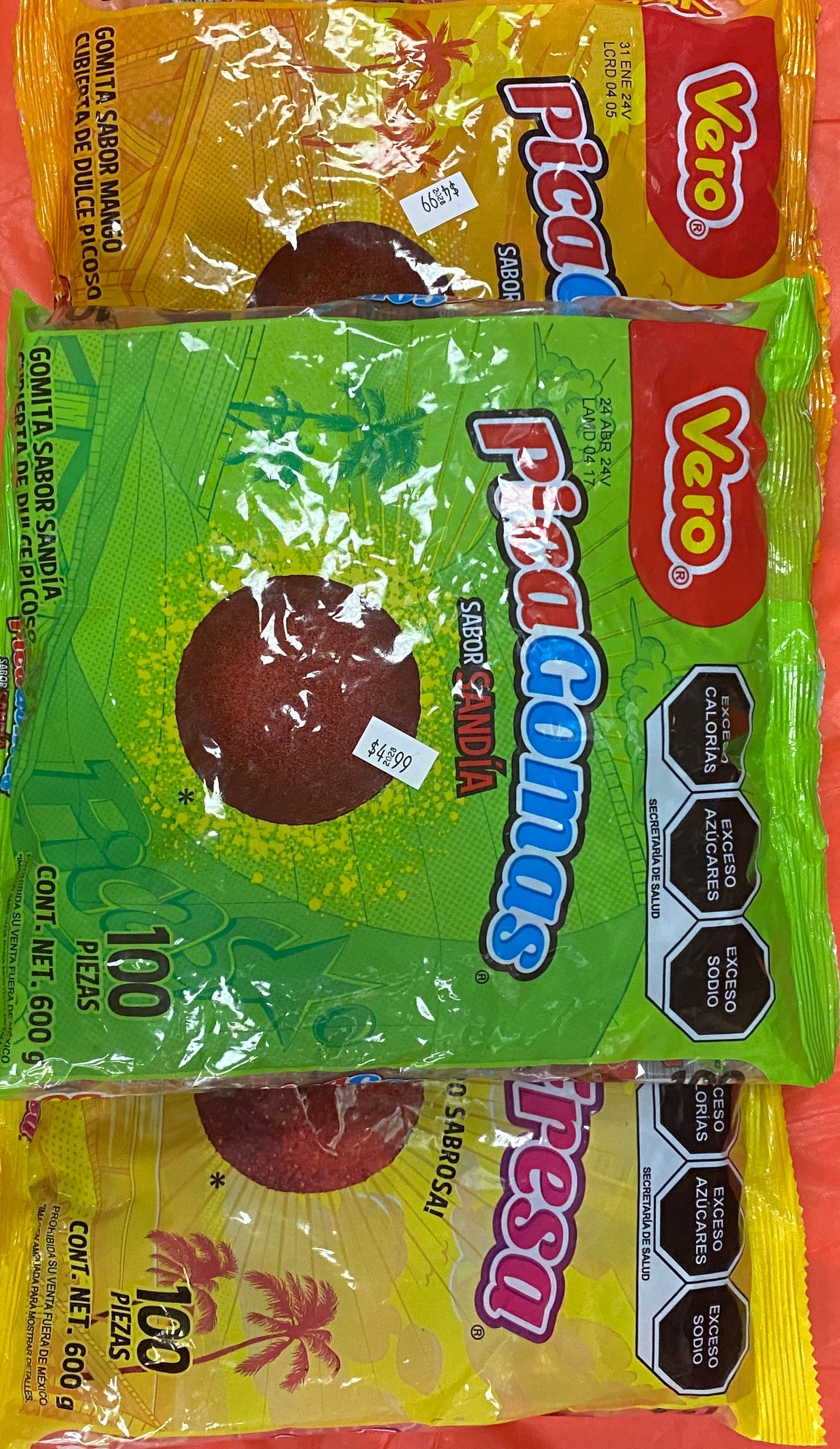 three bags of PicaGomas candy are sitting on top of each other on a table .