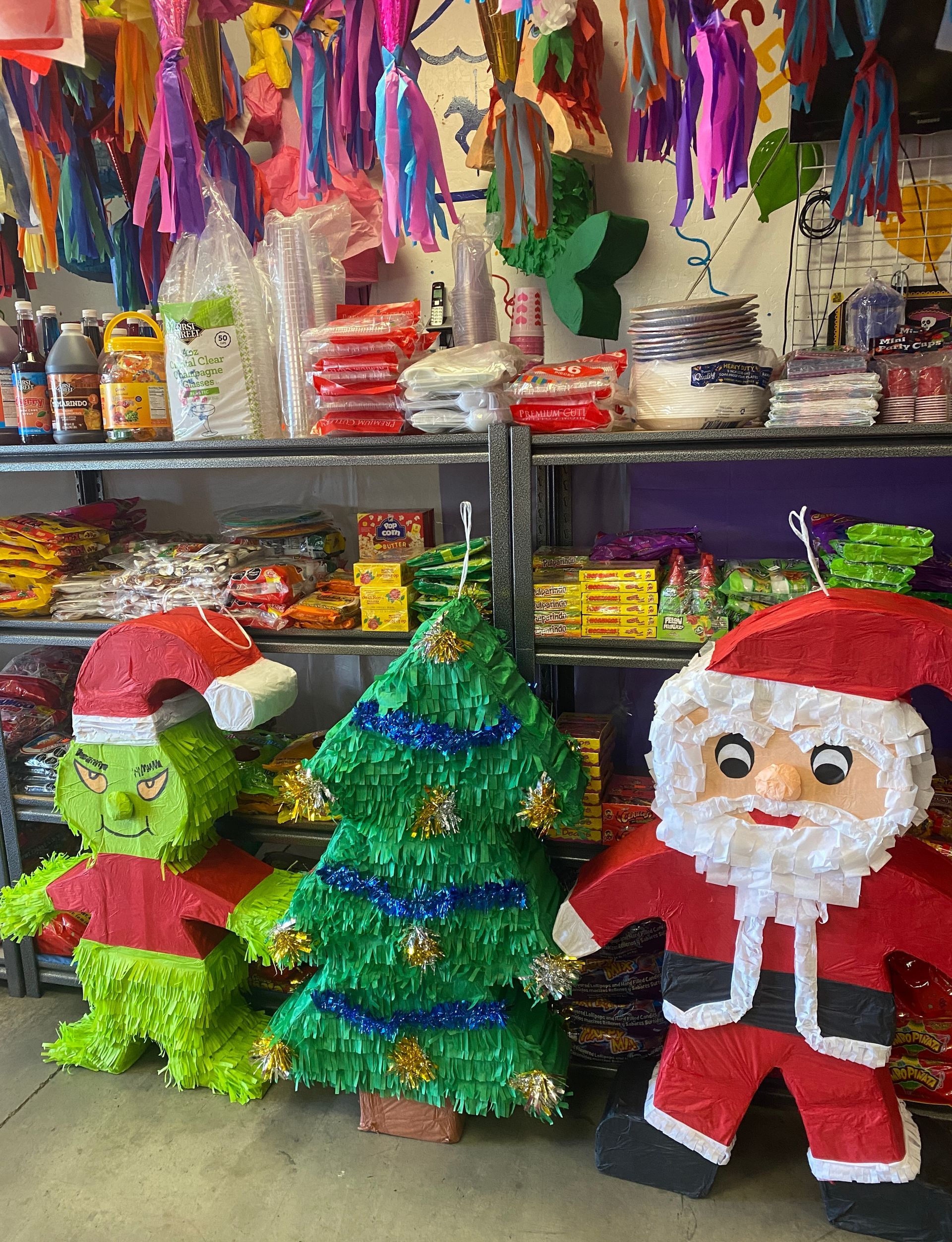 a store filled with lots of christmas decorations including santa claus and a christmas tree pinata.