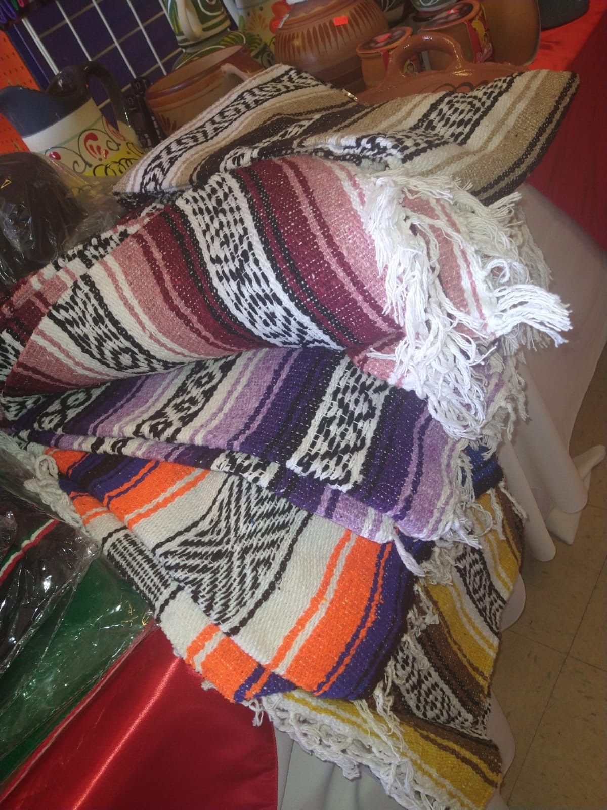 a bunch of colorful blankets are stacked on top of each other on a table .
