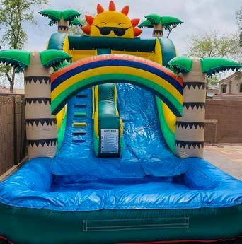 a bouncy house water slide with a rainbow and a sun on top of it .