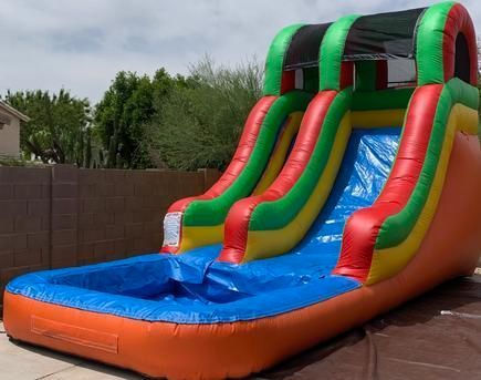 a colorful inflatable water slide is sitting in a driveway .