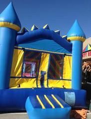 a blue and yellow bouncy house is sitting in front of a building 