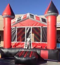 a red and black bouncy house is sitting in front of a building 