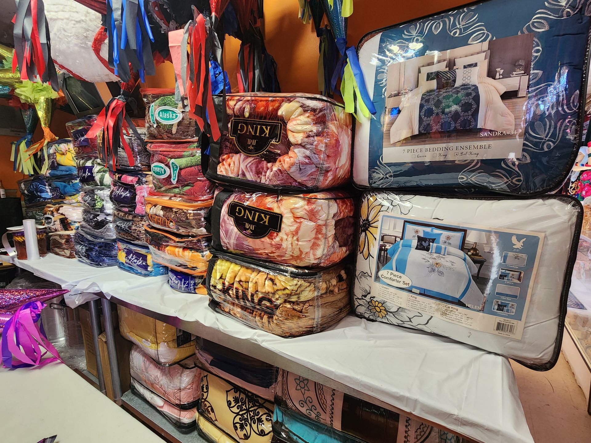 a bunch of blankets are stacked on top of each other on a shelf in a store