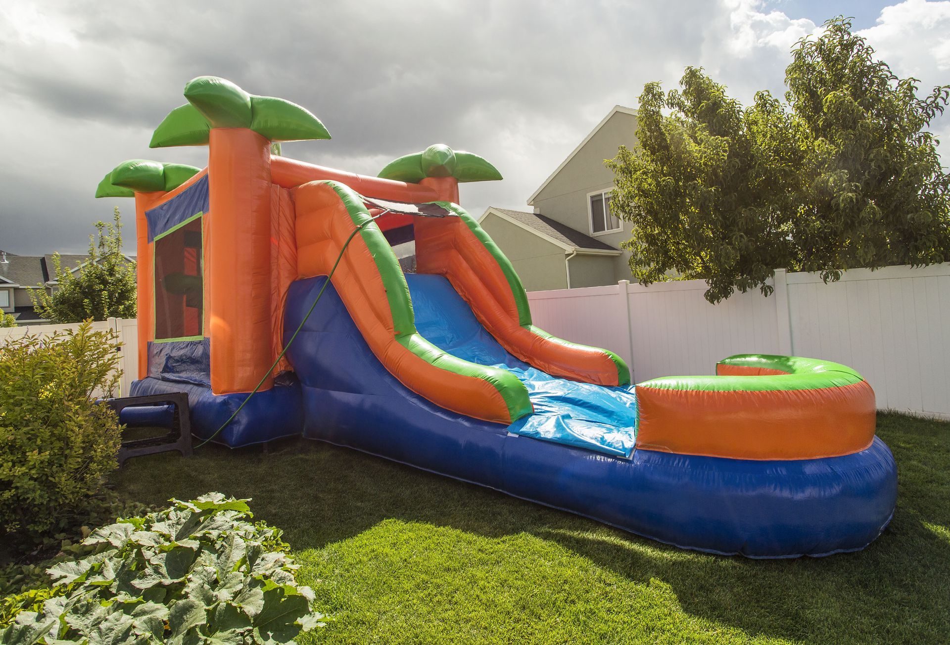 an inflatable water slide is sitting in the grass in a backyard