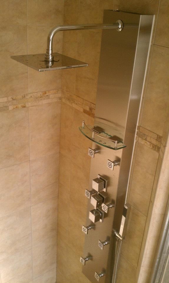 A stainless steel shower head is mounted to a wall in a bathroom.