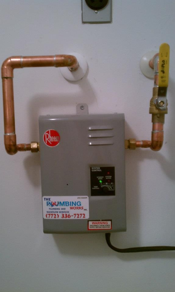 A water heater with copper pipes attached to it