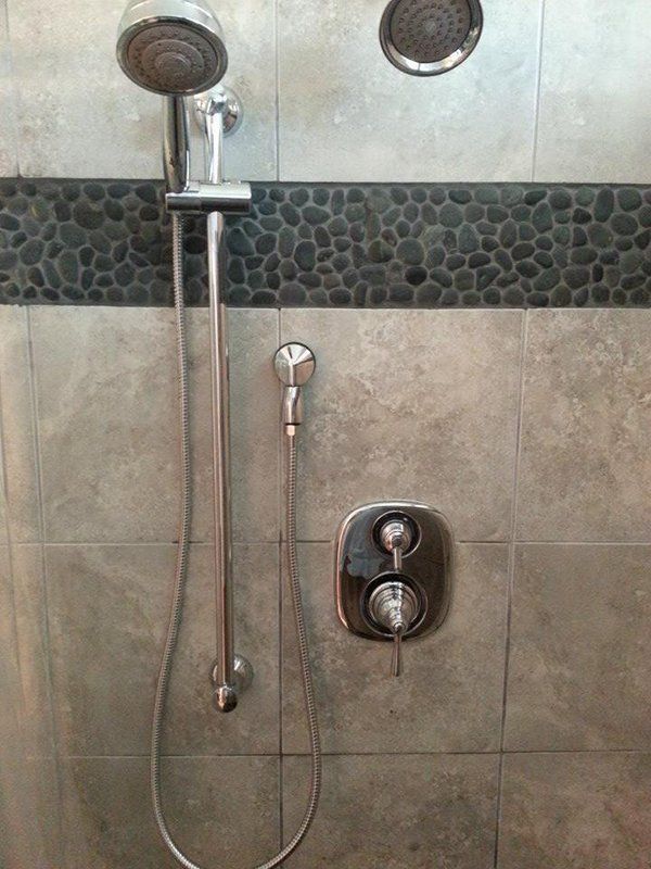 A close up of a shower head in a bathroom.