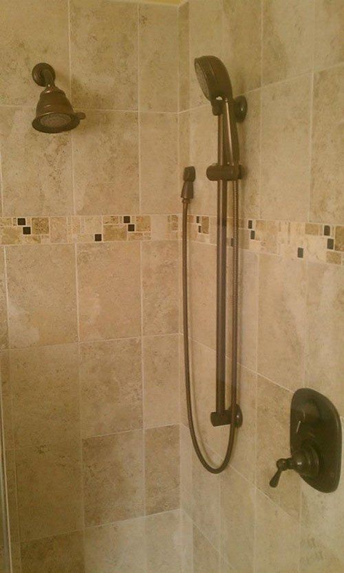 A shower with a shower head and a shower head on the wall.