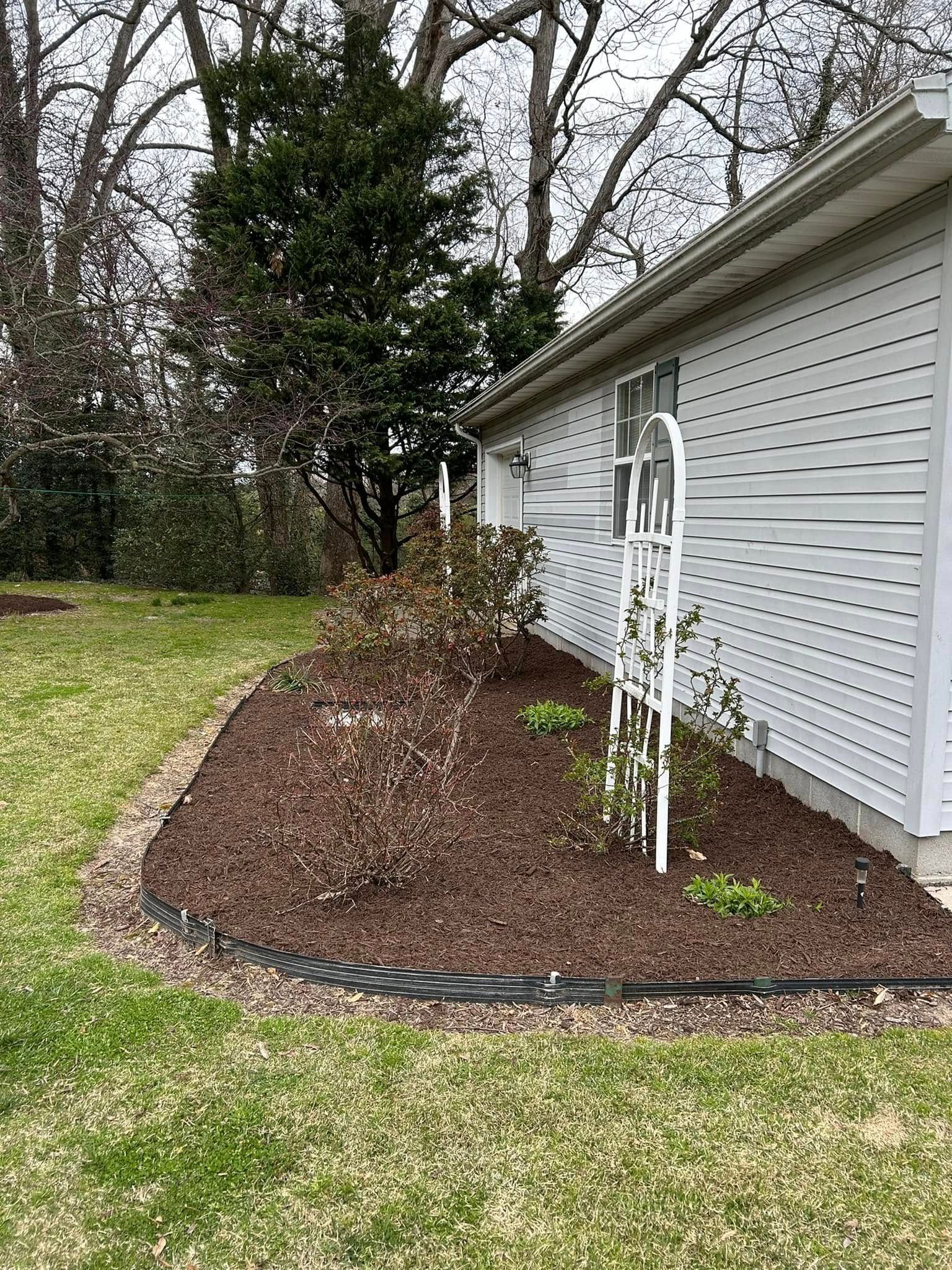 A white house with a garden in front of it.