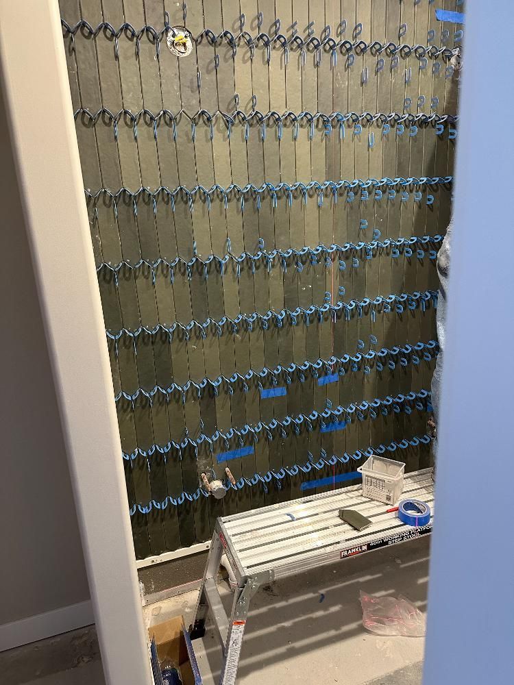 A room with a ladder and a bunch of tiles on the wall.