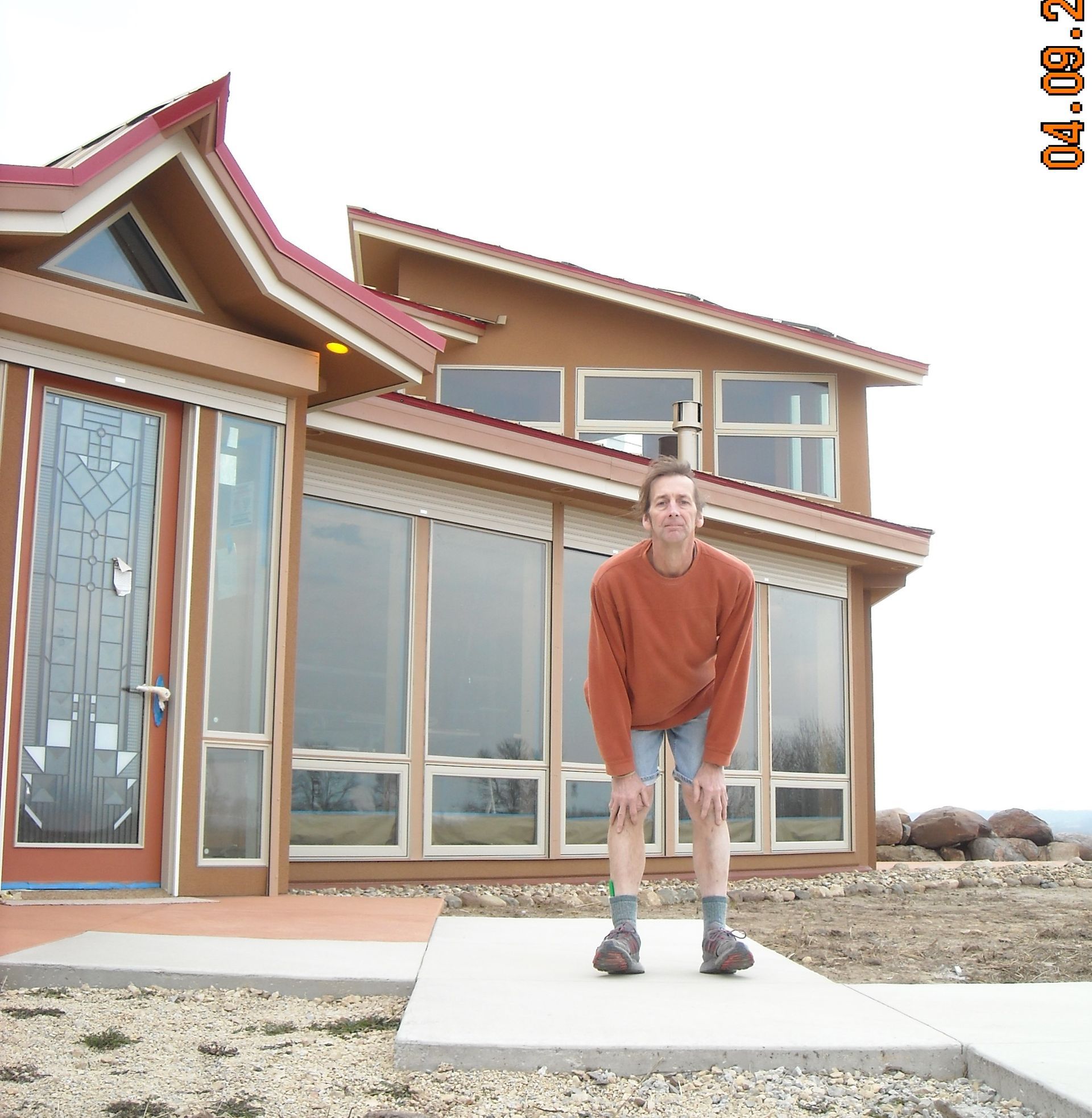 Dennis White in front of a house