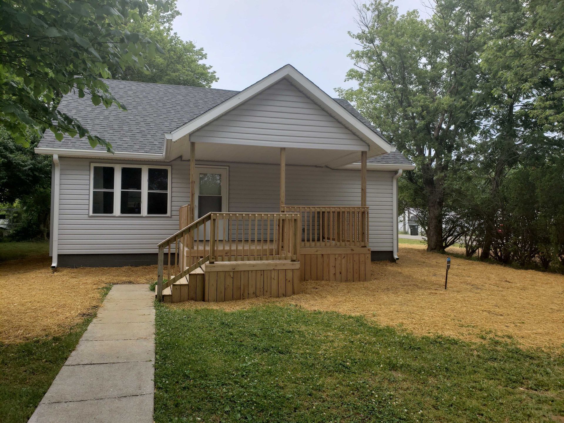 Light gray house with front porch and walkway.