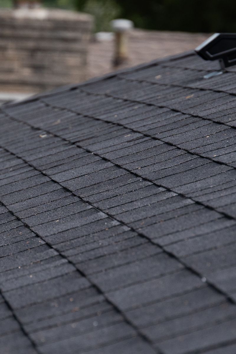 Black asphalt shingle roof, angled view, with a dark gray color.