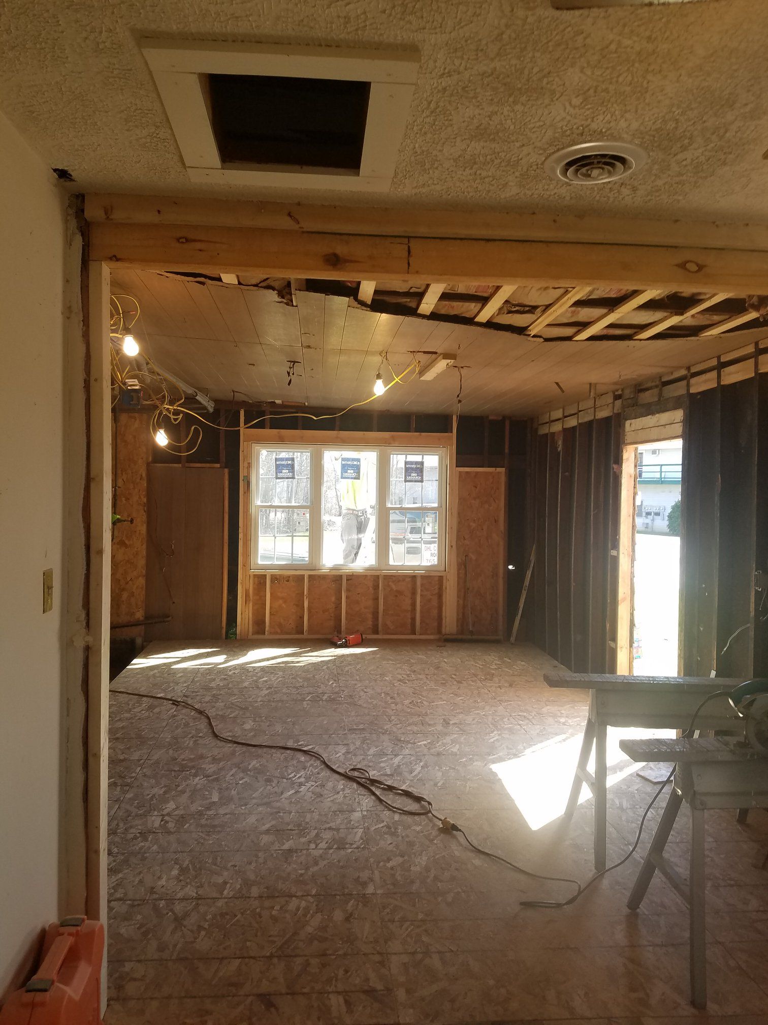 Interior construction: Room gutted with exposed framing and a window.