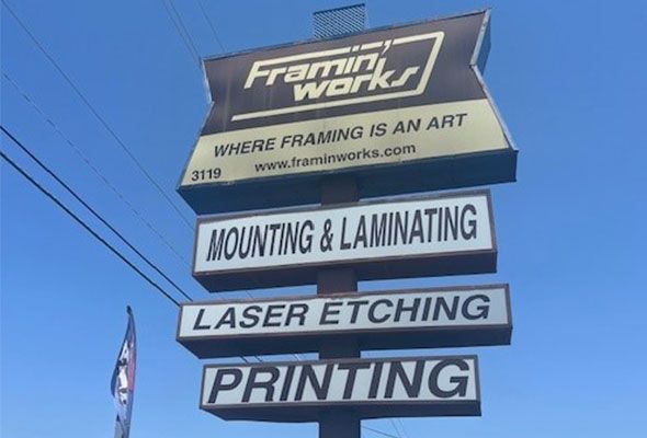 A sign that says framing works mounting and laminating laser etching printing