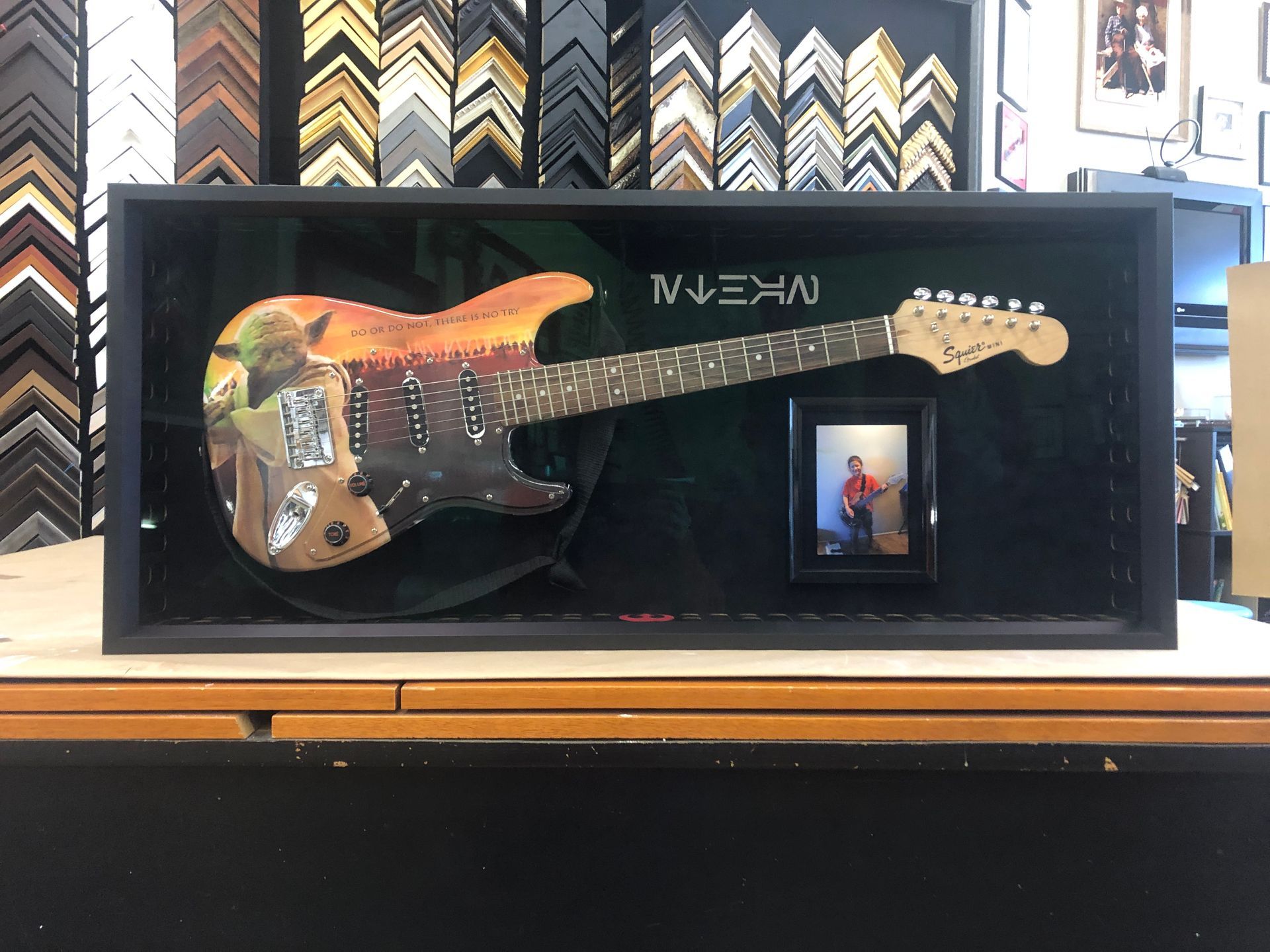 A guitar in a frame with a picture of a man on it