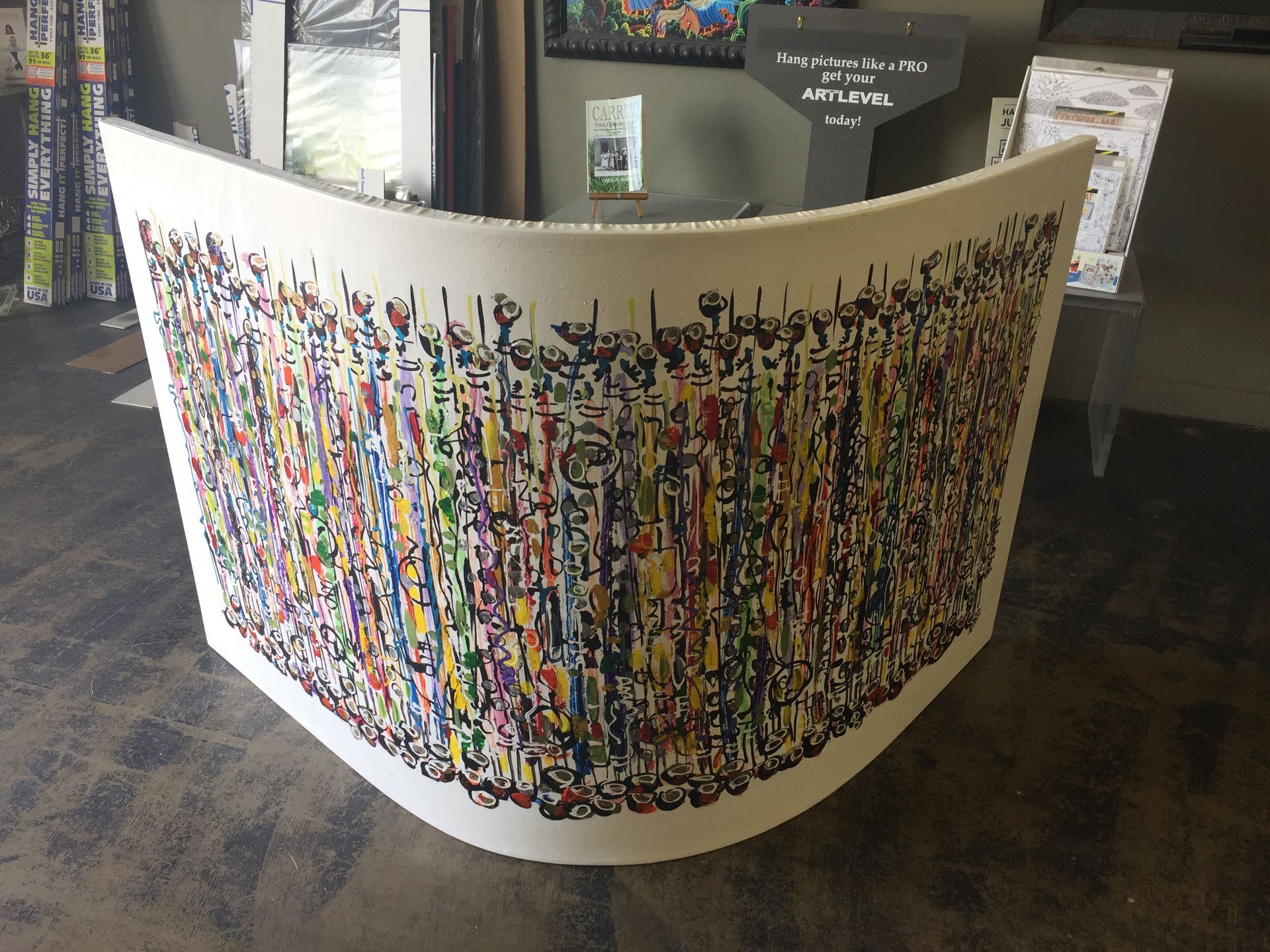 A large colorful painting is on display in a room