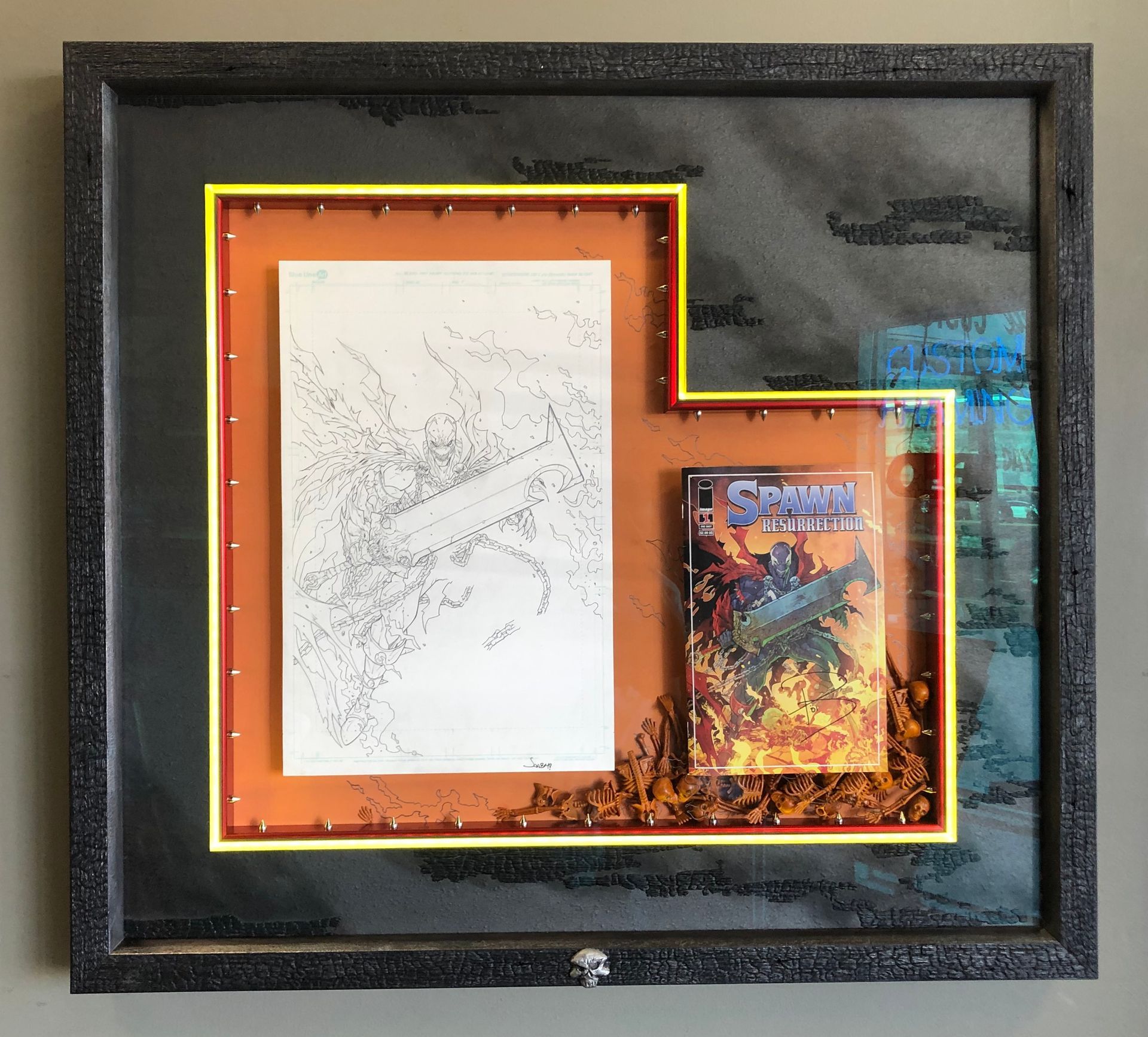A framed picture of a comic book and a drawing.