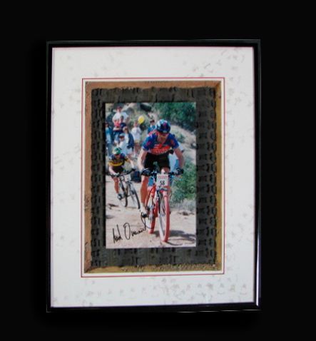 A framed picture of a man riding a bike with the number 22 on his shirt