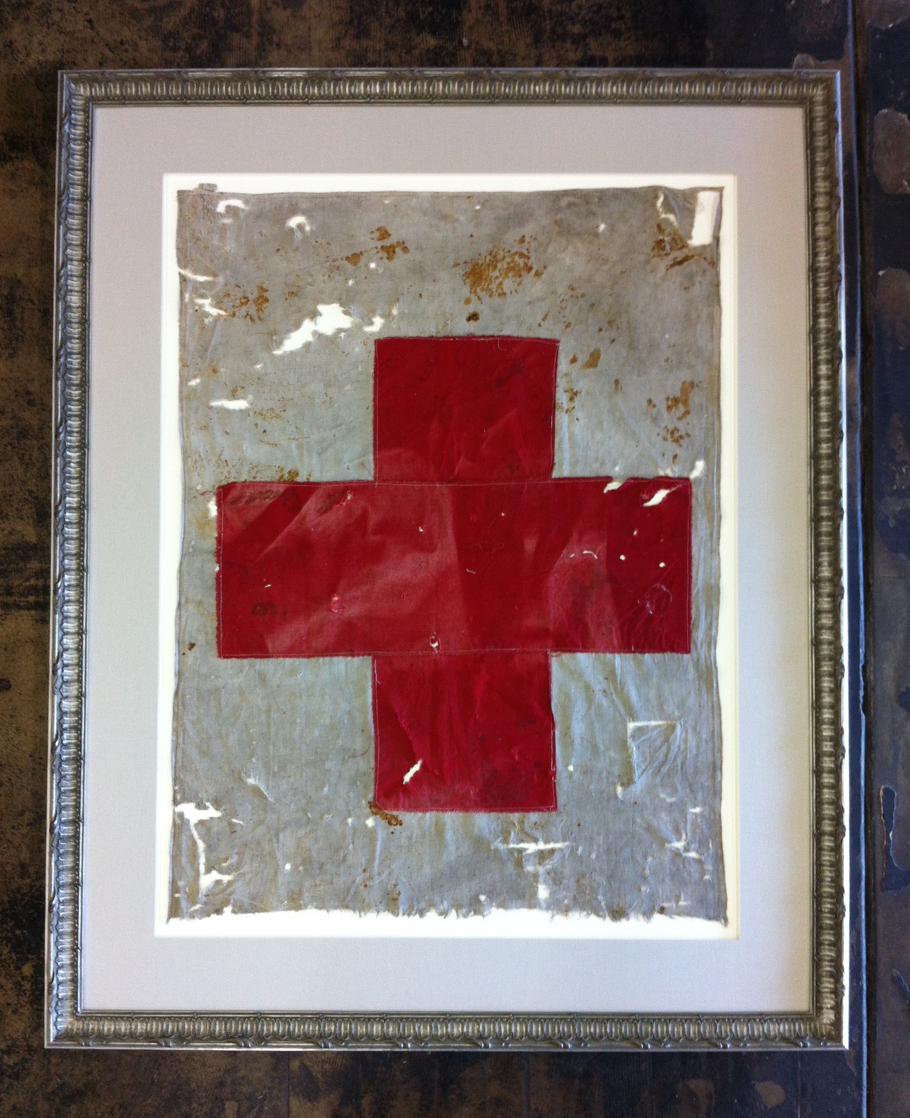 A framed picture of a red cross on a white background