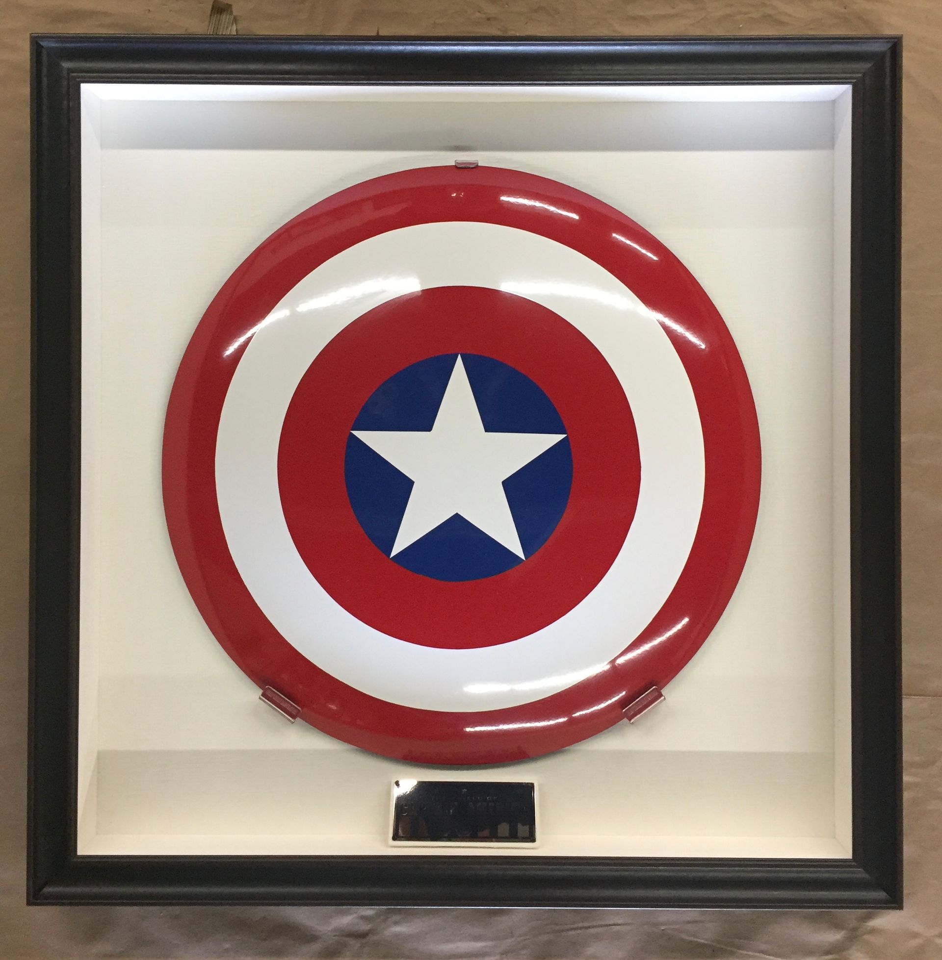 A framed captain america shield with a star in the center