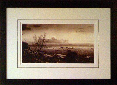 A black and white photo of a landscape in a frame
