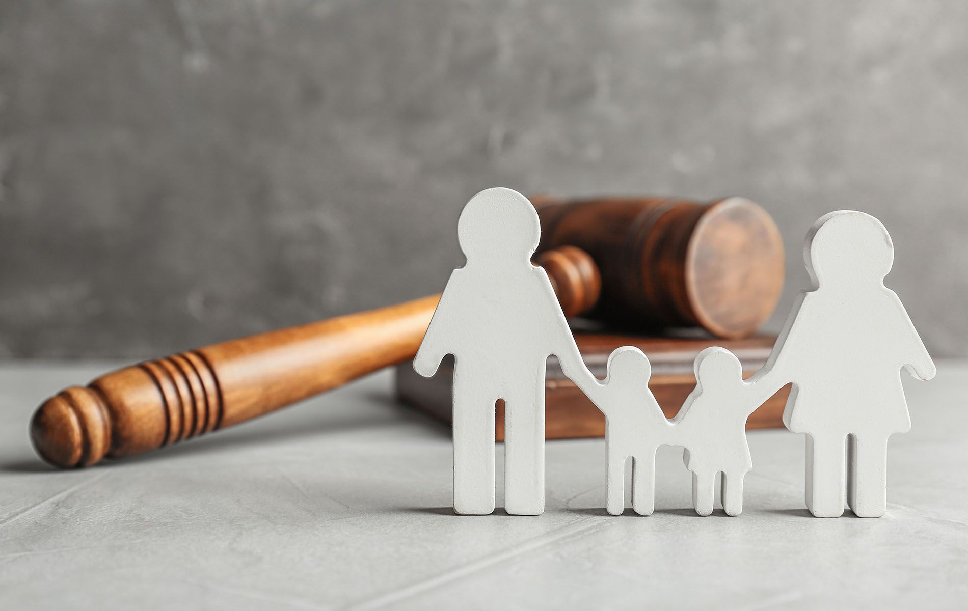 Wooden family figures and gavel on a table, symbolizing family law.