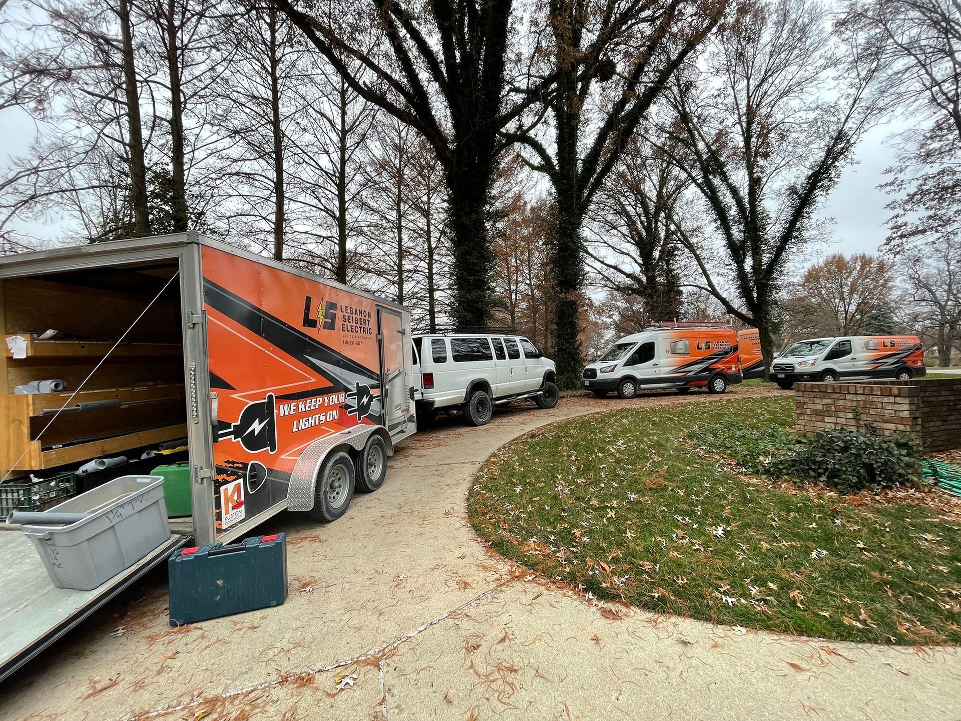 A group of trucks are parked in a driveway.