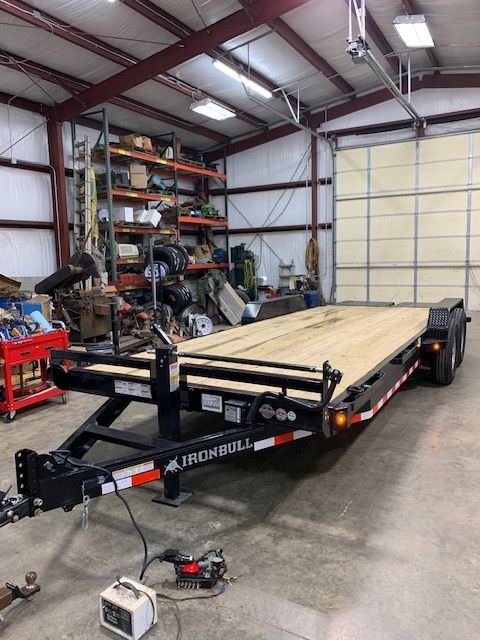 Black Iron Bull flatbed trailer parked inside a workshop.
